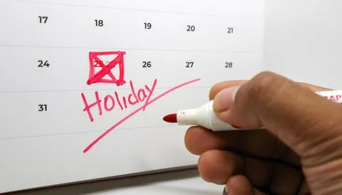 A hand writes "Holiday" under the 25th, which is crossed out in red on a ca.. Stock Photos