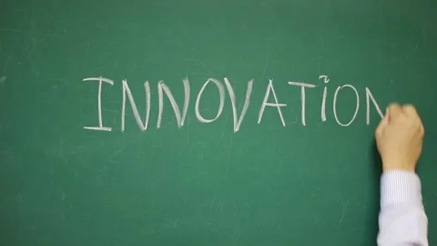 Hand writes INNOVATION on a blackboard Stock Footage 135839476