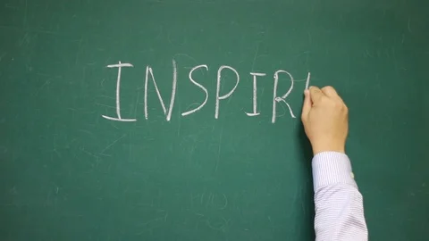 Hand writes INSPIRE on a blackboard Stock Footage 123713089
