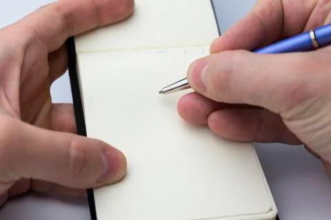 Hand writes in a notebook. Stock Photos