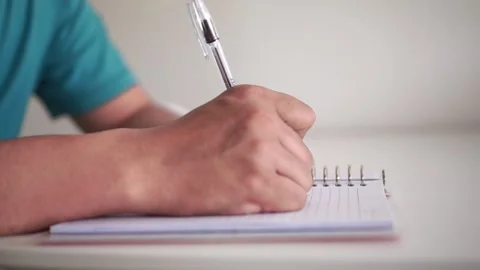 A hand writes in a notebook, realizes an error, crosses it out, and tears the Stock Footage 340323402