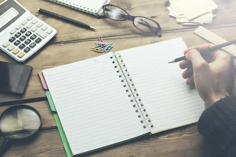 Hand writes pencil in a notebook Stock Photos