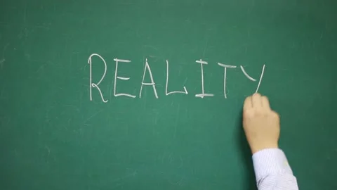 Hand writes REALITY on a school blackboard Vídeo Stock 140933912