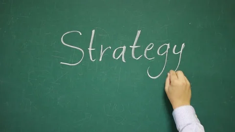 Hand writes STRATEGY on a chalkboard Stock Footage 123673310