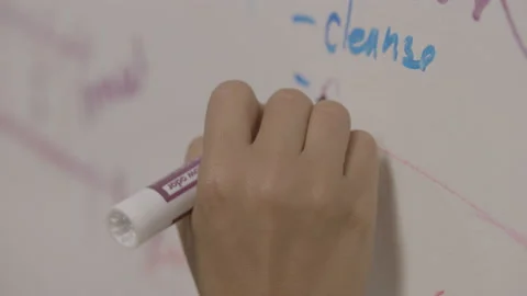 Hand writes on whiteboard using a marker Stock Footage 134582918