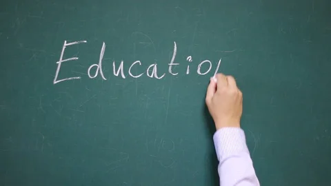 Hand writes the word Education on a school blackboard Stock Footage 123671358