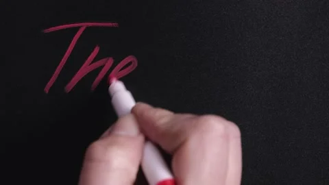The hand writes the word the end with a felt-tip pen on the blackboard Stock Footage 145112897