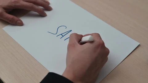 A hand writes the word safe on a piece of paper, followed by creating a shield Видео 337550357