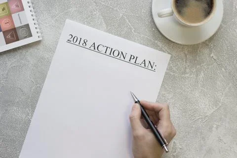 Hand writing 2018 action plan, a cofee cup, a notebook Stock Photos