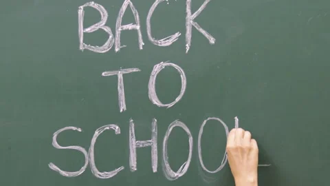 Hand is writing on blackboard with white chalk word back to school Stock Footage 204860829