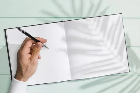Hand writing blank notebook shadow leaves Stock Photos