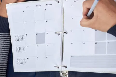 Hand writing on calendar planner in a ring-bound notebook Stock Photos