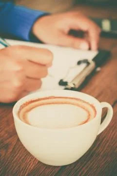 Hand writing with cup of coffee Stock Photos