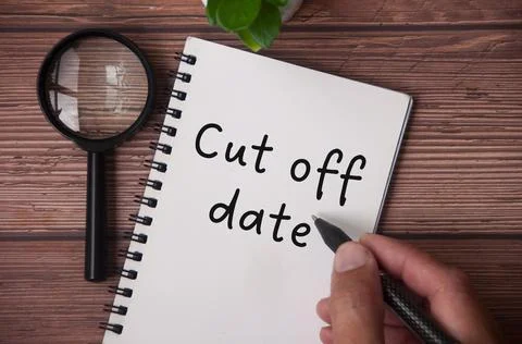 Hand writing cut of date on notepad with table plant Stock Photos