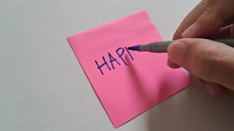 Hand writing happy message on pink sticky note video footage Stock Footage 339505686