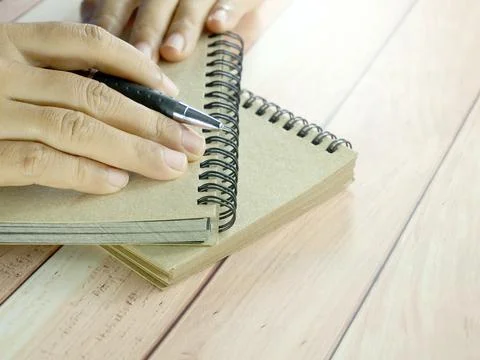 Hand writing in notebook on brown background. Insurance or financial busine.. Stock Photos