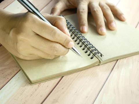 Hand writing in notebook on brown background. Insurance or financial busine.. Stock Photos