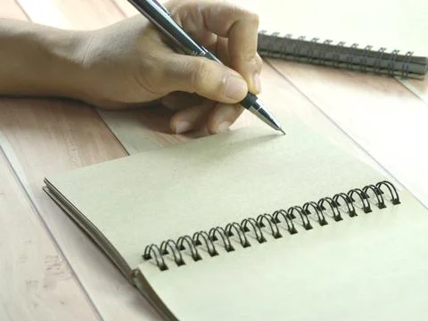 Hand writing in notebook on brown background. Insurance or financial busine.. Stock Photos