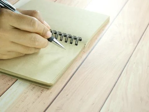 Hand writing in notebook on brown background. Insurance or financial busine.. Stock Photos