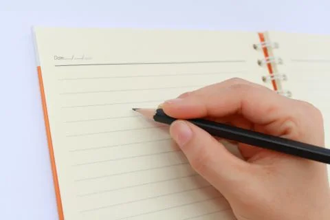 A hand writing on a notebook Stock Photos
