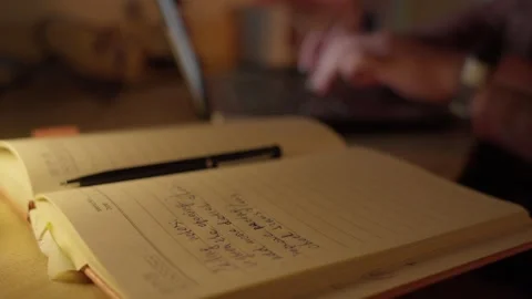 Hand Writing Notes in Notebook at Desk in Warm Light Stock Footage 344946638