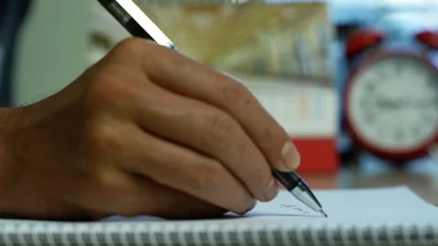 Hand writing notes in a spiral notebook, Close-up of a person writing with .. 스톡 동영상 346484071