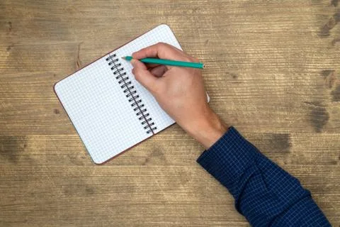 Hand writing in open notebook Stock Photos
