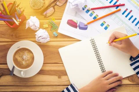 Hand writing in open notebook on table at morning Stock Photos
