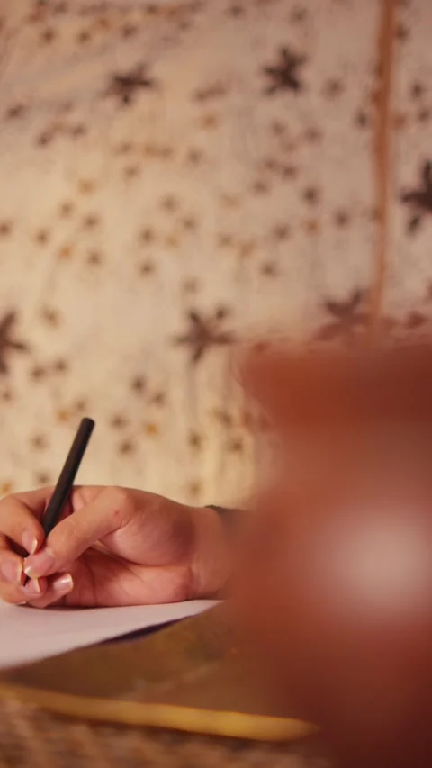 Hand Writing on Paper Close-Up with Batik Background Stock Footage 262534328
