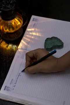 A hand writing something on an office notebook with pen eye glasses with a la Stock Photos