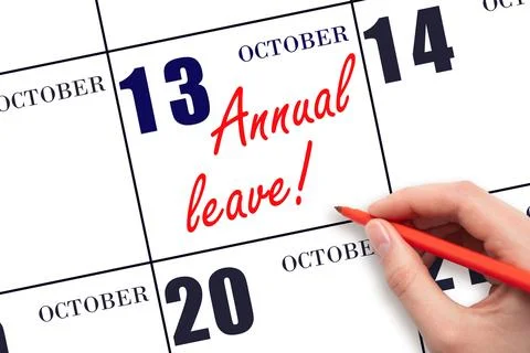 Hand writing the text ANNUAL LEAVE and drawing the sun on the calendar date.. Stock Photos