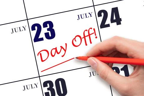 Hand writing text DAY OFF and drawing a line on calendar date 23 July. Vacati Stock Photos