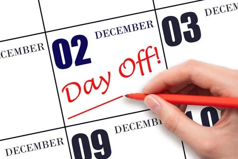 Hand writing text DAY OFF and drawing a line on calendar date 2 December. Vac Stock Photos