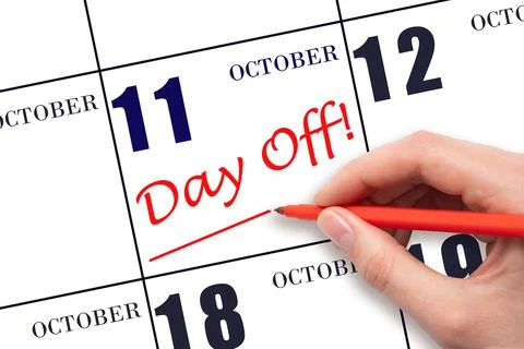 Hand writing text DAY OFF and drawing a line on calendar date 11 October. Vac Stock Photos