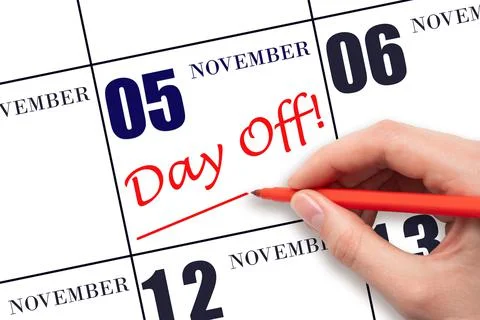 Hand writing text DAY OFF and drawing a line on calendar date 5 November. Vac Stock Photos