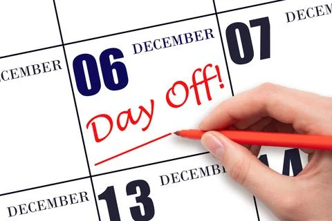 Hand writing text DAY OFF and drawing a line on calendar date 6 December. Vac Stock Photos
