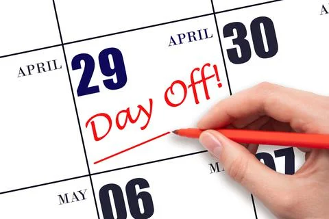 Hand writing text DAY OFF and drawing a line on calendar date 29 April. Vacat Stock Photos