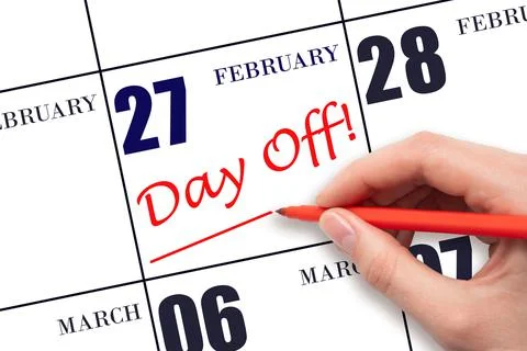 Hand writing text DAY OFF and drawing a line on calendar date 27 February. Va Stock Photos