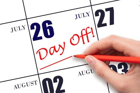 Hand writing text DAY OFF and drawing a line on calendar date 26 July. Vacati Stock Photos