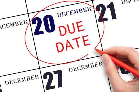 Hand writing text DUE DATE on calendar date December 20 and circling it. Paym Stock Photos