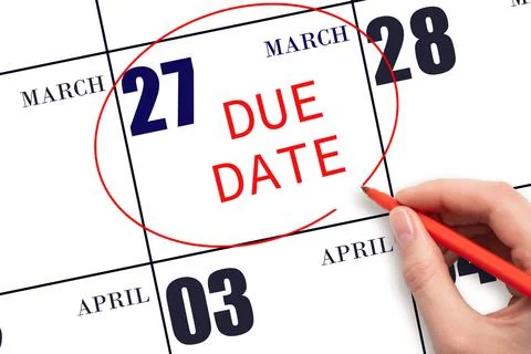 Hand writing text DUE DATE on calendar date March 27 and circling it. Payment Stock Photos