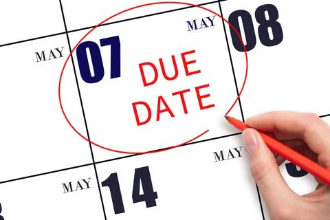 Hand writing text DUE DATE on calendar date May 7 and circling it. Payment du Stock Photos