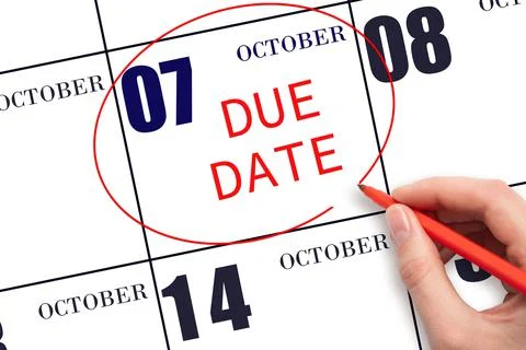 Hand writing text DUE DATE on calendar date October 7 and circling it. Paymen Stock Photos