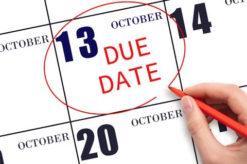 Hand writing text DUE DATE on calendar date October 13 and circling it. Payme Stock Photos