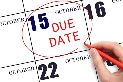 Hand writing text DUE DATE on calendar date October 15 and circling it. Payme Stock Photos