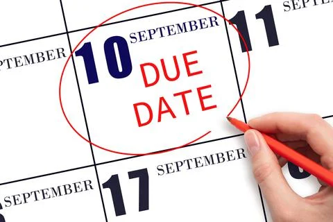 Hand writing text DUE DATE on calendar date September  10 and circling it. Pa Stock Photos