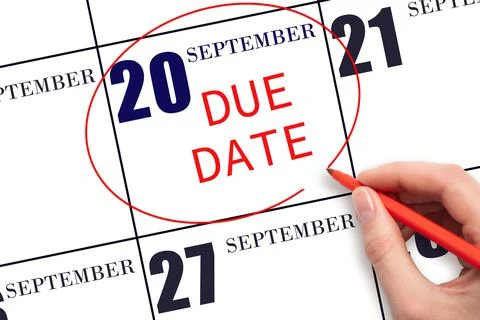 Hand writing text DUE DATE on calendar date September  20 and circling it. Pa Stock Photos