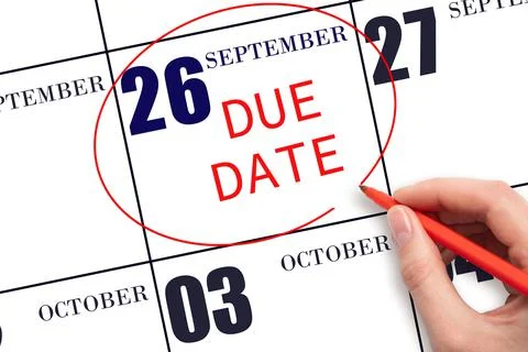 Hand writing text DUE DATE on calendar date September  26 and circling it. Pa Stock Photos