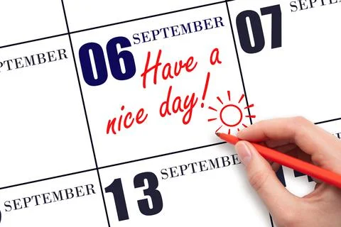 The hand writing the text Have a nice day and drawing the sun on the calendar Stock Photos