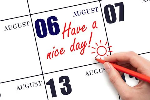 The hand writing the text Have a nice day and drawing the sun on the calendar Stock Photos